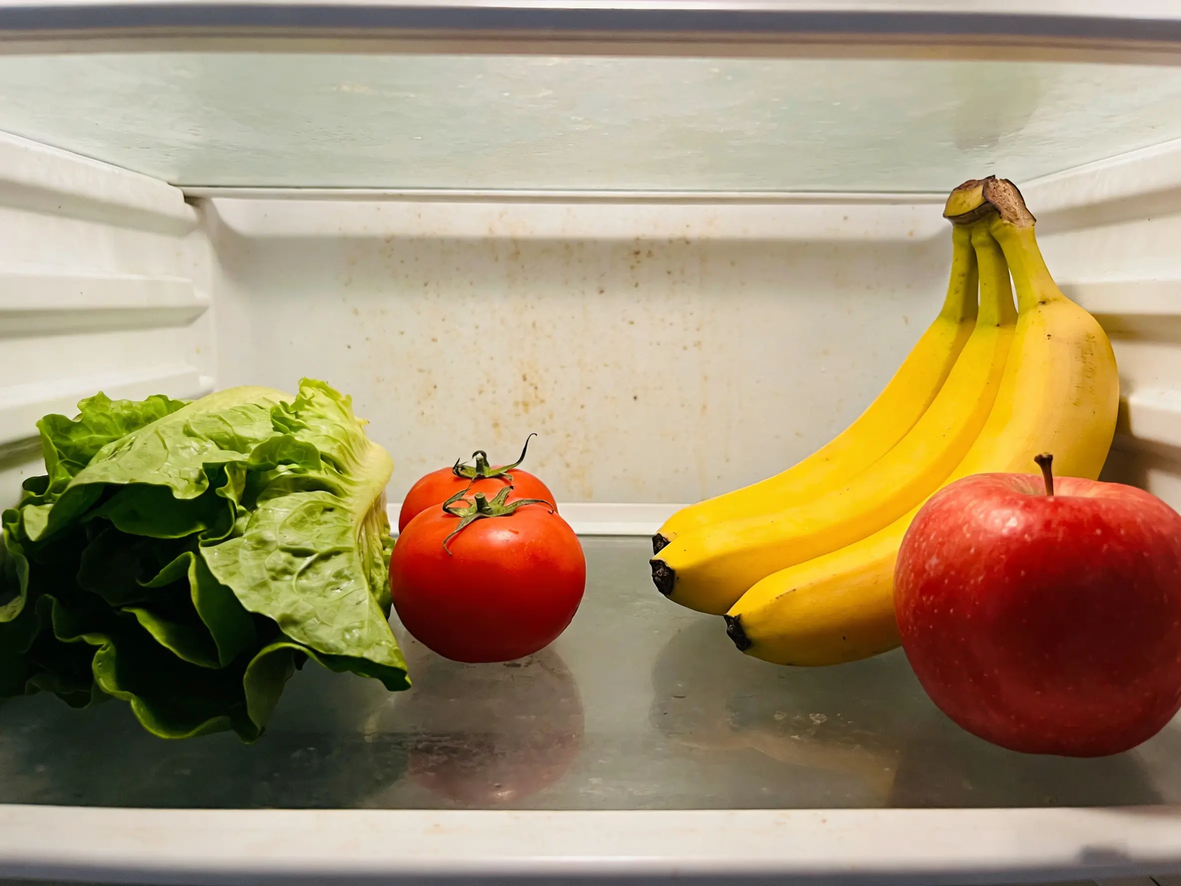 Cleaning Refrigerator with Microfiber Cloth A clean and sparkling refrigerator interior after being wiped with a microfiber cloth