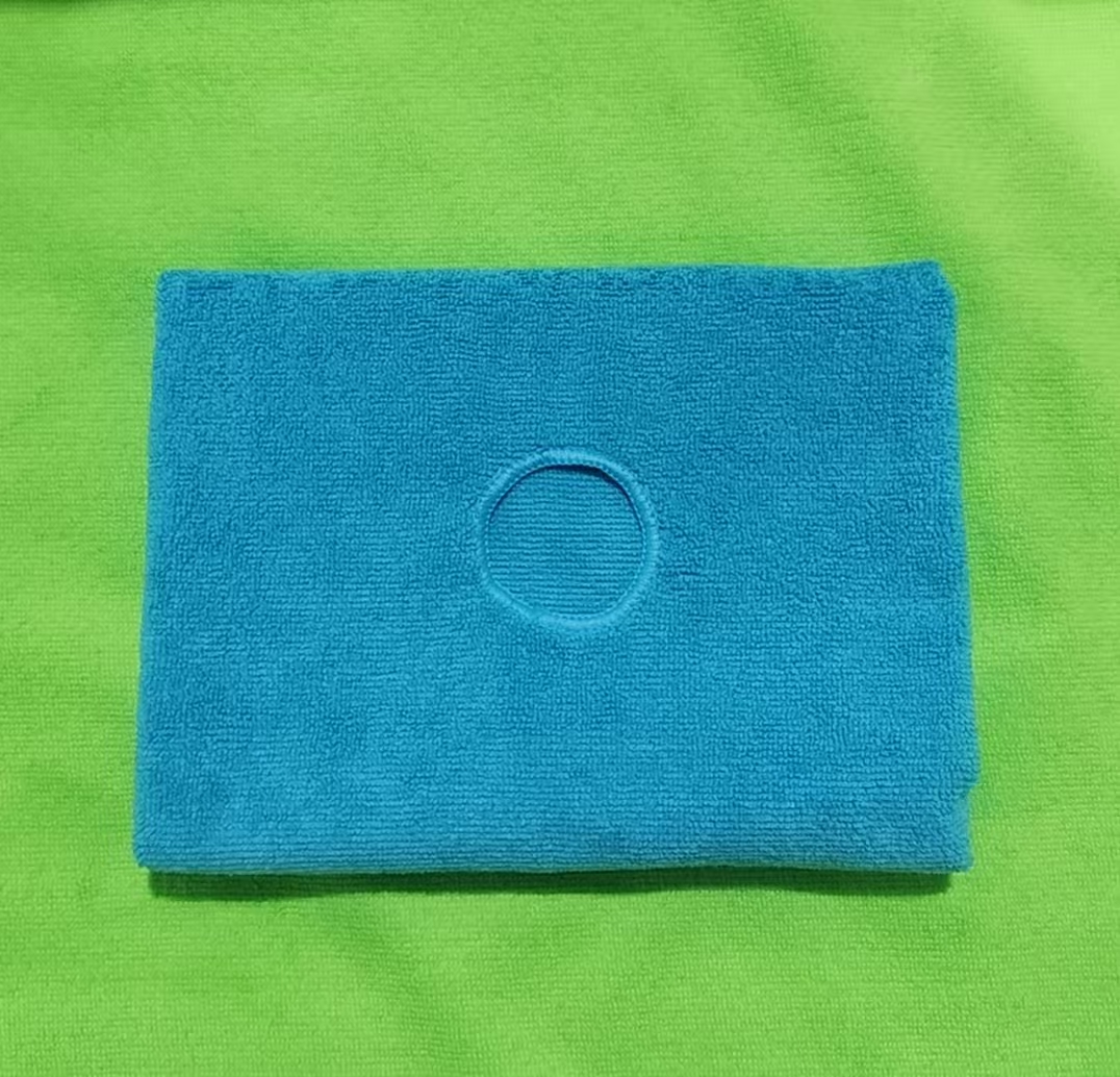 A close-up of a red eyelet on a blue microfiber mop cloth.