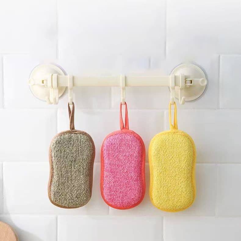 Dishwashing sponge vs dishcloth A collection of different dishwashing sponges and cloths on a kitchen counter