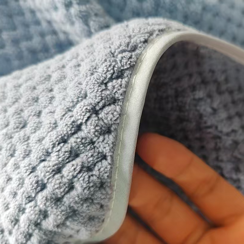 Close-up of neatly stitched edge on thick waffle-weave microfiber towel