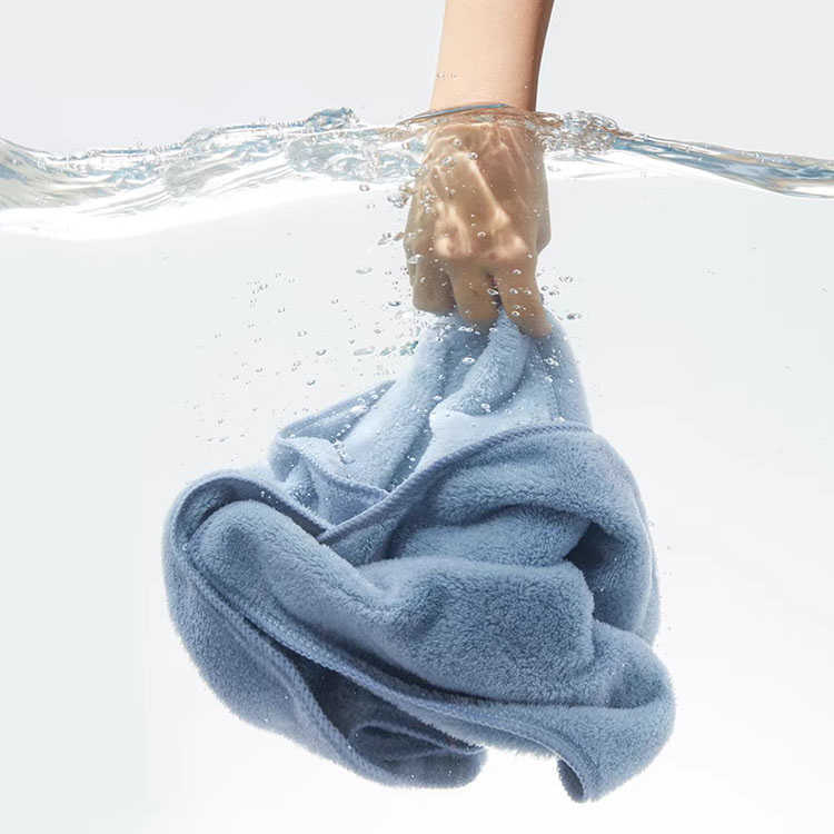 Blue microfiber fleece cloth submerged in water, demonstrating its soak capacity