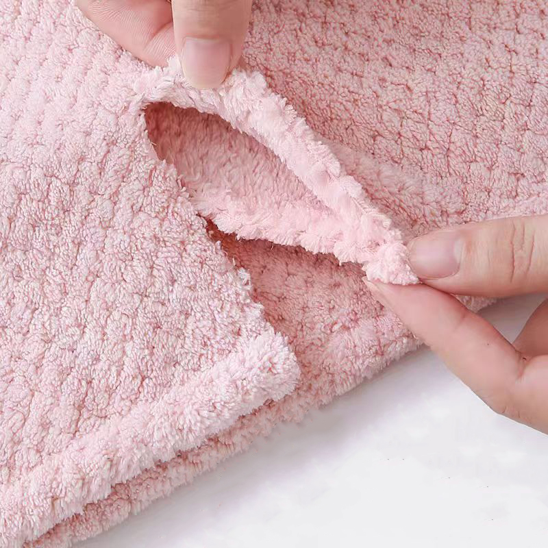 Close-up of thick pink coral fleece towel being folded to show soft interior