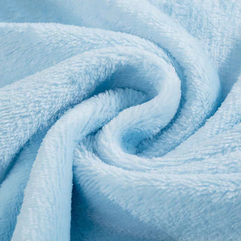 Swirl close-up of pale blue fluffy microfiber coral fleece fabric