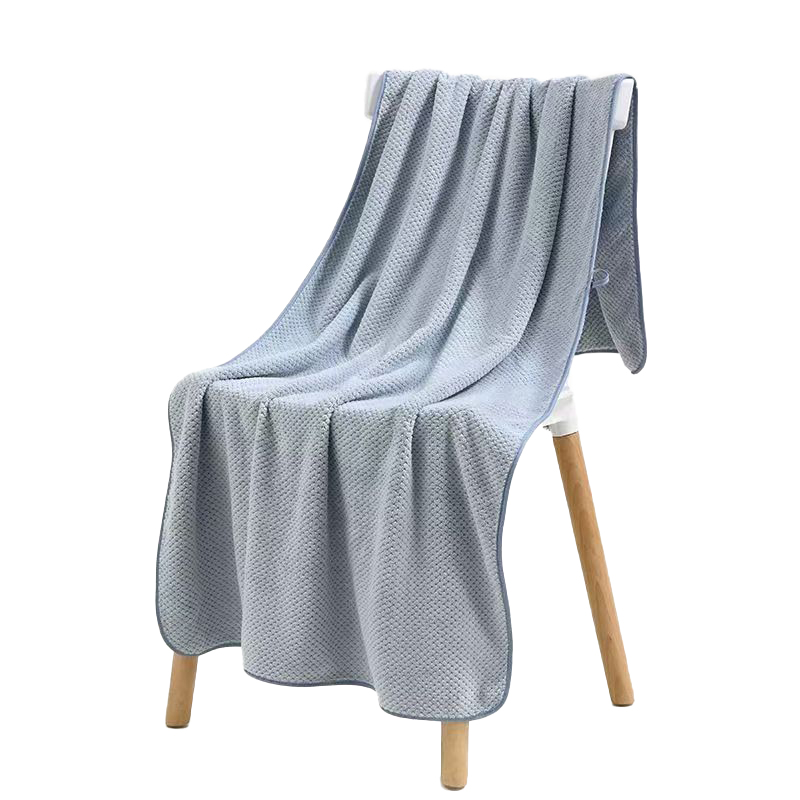 Gray microfiber towel draped over a wooden chair, showcasing size and soft texture